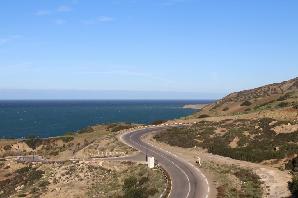 Explore the winding coastal road with ocean views in Mostaganem, Algeria.