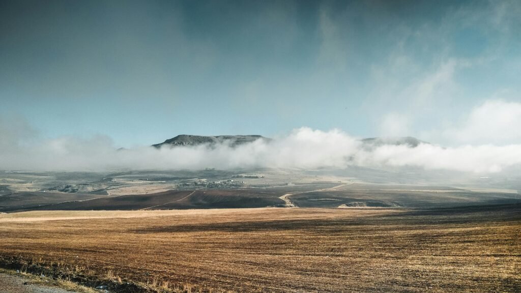 A captivating view of fog rolling over highland fields in Sétif, Algeria.