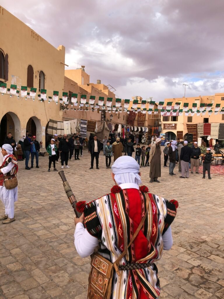 A vibrant street festival in Ghardaïa, showcasing Algerian culture with traditional costumes and live performances.