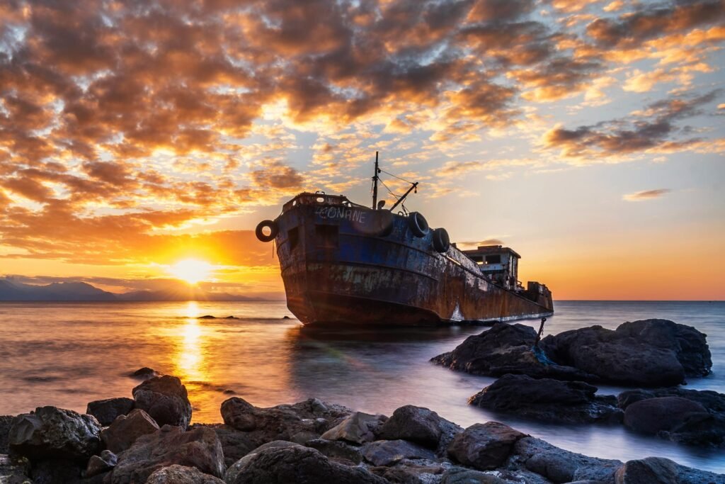 Stunning image of a shipwreck at sunset in Jijel Province, Algeria, with vibrant colors.